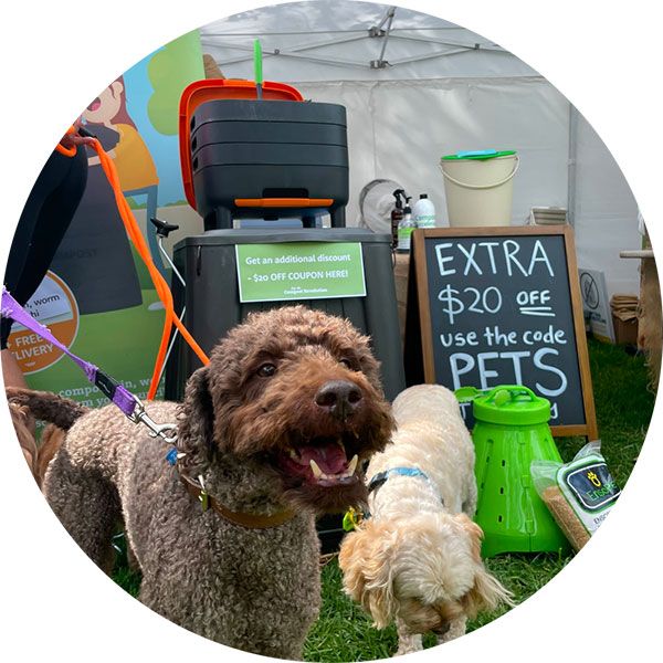 Dogs at a festival with Compost Revolution stall in the background
