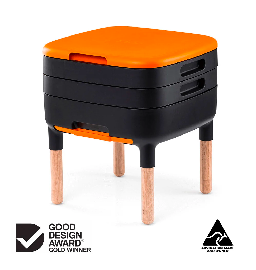 The Farm worm farm with burnt orange lid, black body and wooden legs